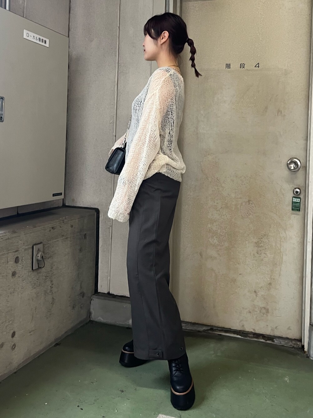 ホワイト系のニット/セーター、グレー系のその他パンツ、ブラック系のブーツを着用したレディースの秋コーディネートの4枚目の写真