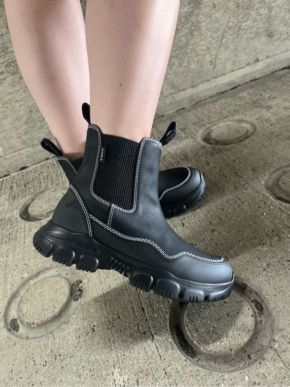 ブラック系のキャミソール、ブラック系のブーツ、ブルー系のカーディガン/ボレロを着用したレディースの秋コーディネートの6枚目の写真