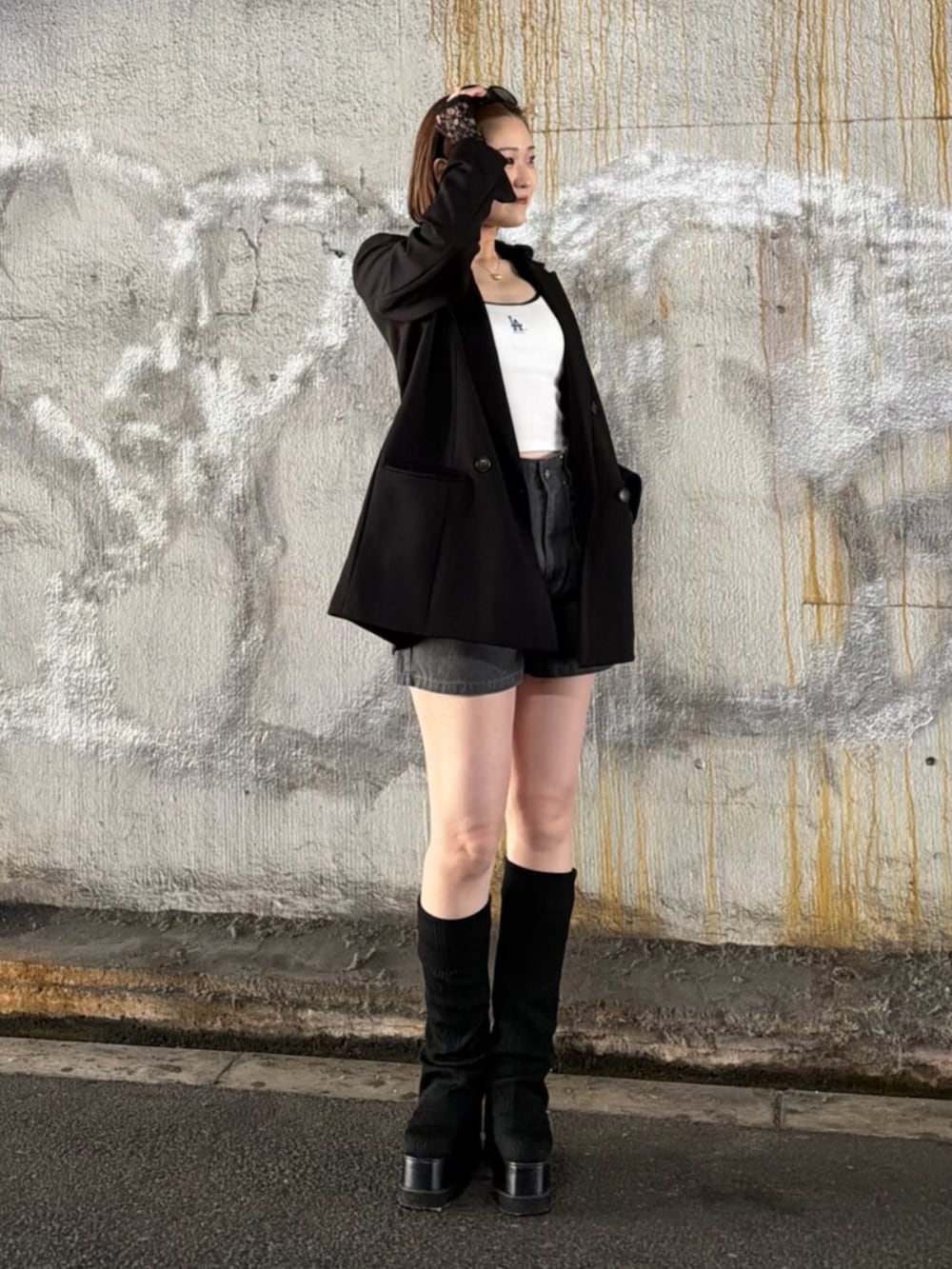 ブラック系のテーラードジャケット、ブラック系のパーカー、ホワイト系のキャミソールを着用したレディースの春コーディネートの3枚目の写真