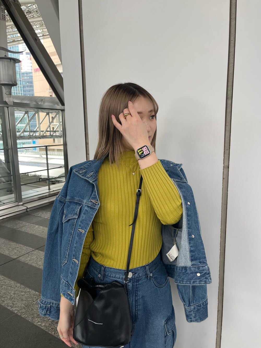 グリーン系のニット/セーター、ブルー系のデニムパンツ、グレー系のスニーカーを着用したレディースの冬コーディネートの5枚目の写真