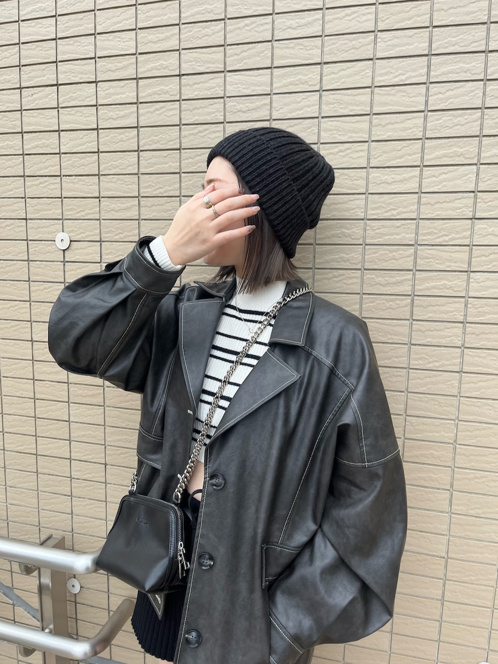 グレー系のブルゾン、その他のニット/セーター、ブラック系のハンドバッグを着用したレディースの冬コーディネートの6枚目の写真