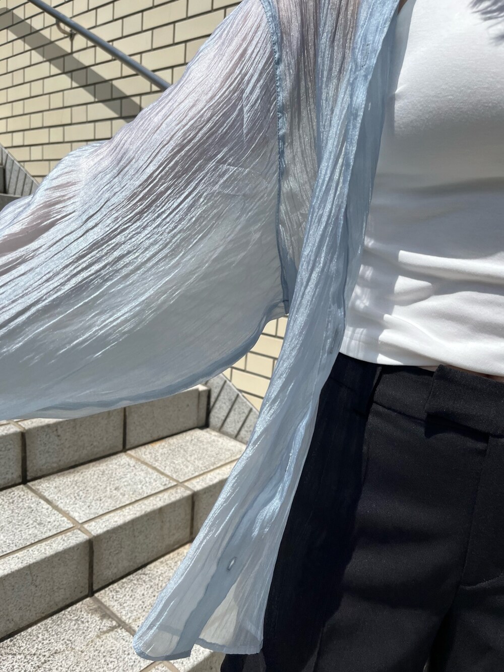 ブルー系のシャツ/ブラウス、ブラック系のスラックス、ホワイト系のTシャツ/カットソーを着用したレディースの春コーディネートの5枚目の写真