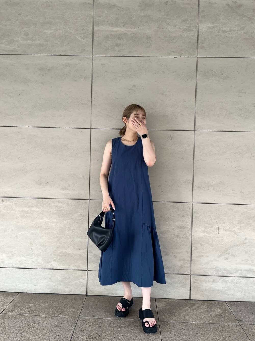 ブルー系のワンピース、ホワイト系のシャツ/ブラウス、ブラック系のサンダルを着用したレディースの夏コーディネートの3枚目の写真