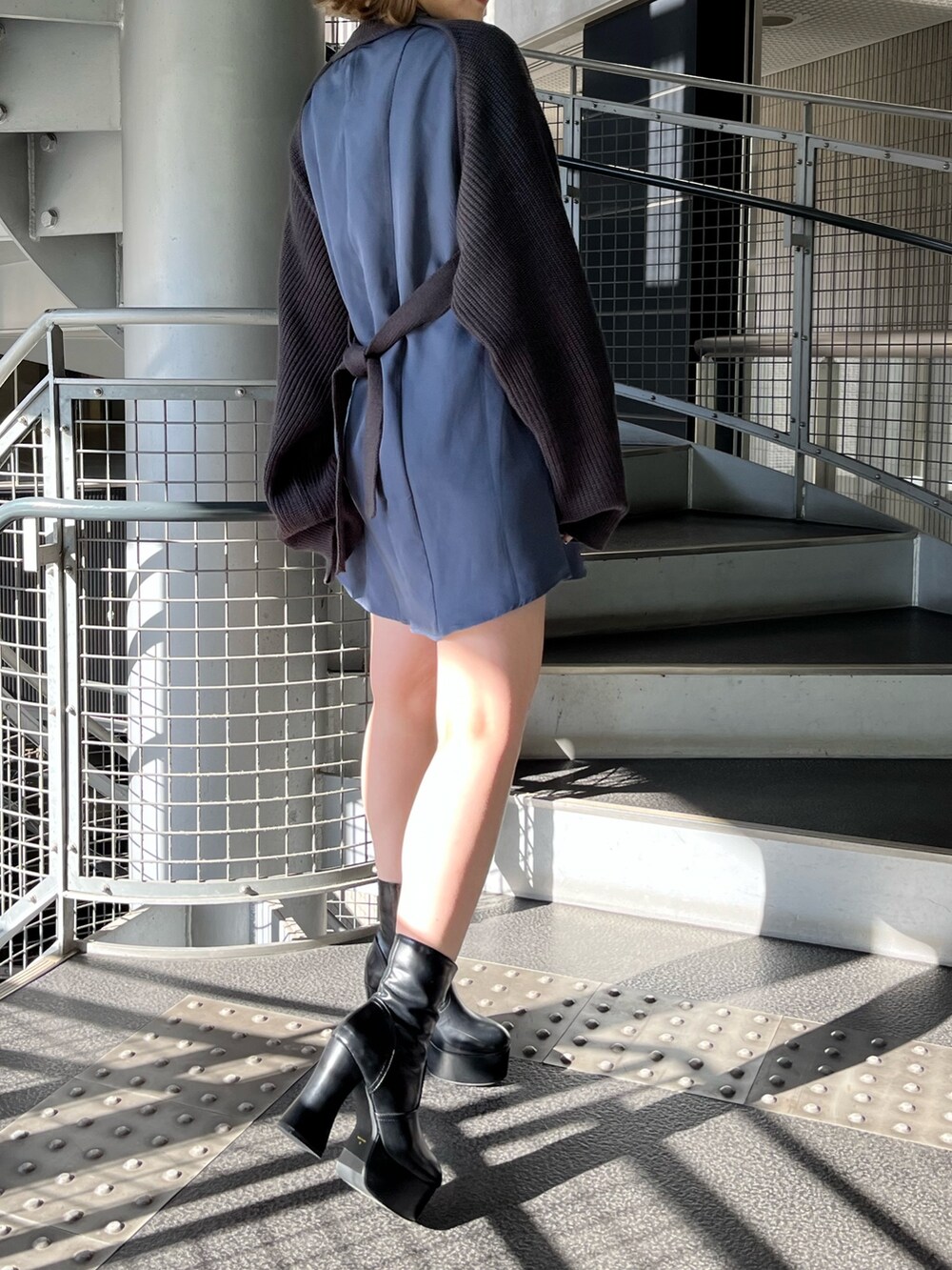 グレー系のワンピース、ブラック系のブーツを着用したレディースの冬コーディネートの4枚目の写真