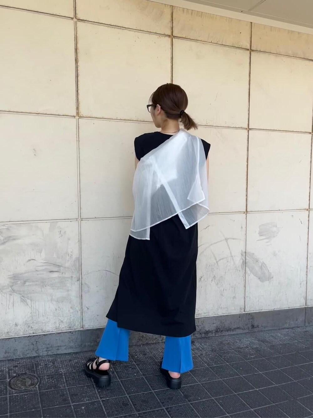 ホワイト系のシャツ/ブラウス、ブルー系のスラックス、ブラック系のサンダルを着用したレディースの夏コーディネートの2枚目の写真