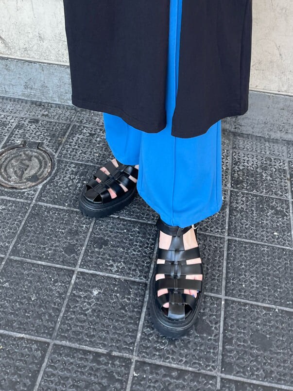 ホワイト系のシャツ/ブラウス、ブルー系のスラックス、ブラック系のサンダルを着用したレディースの夏コーディネートの5枚目の写真
