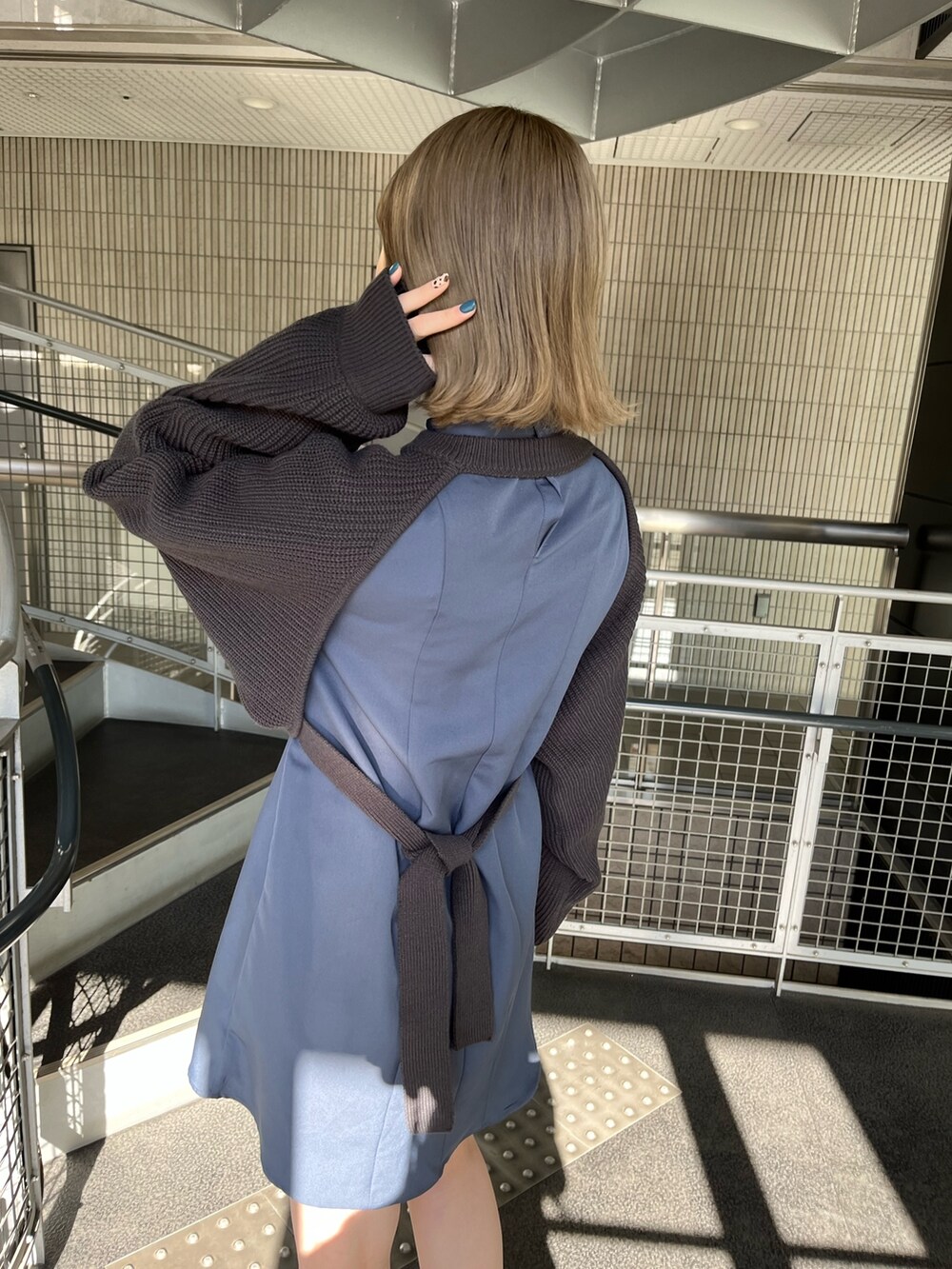 グレー系のワンピース、ブラック系のブーツを着用したレディースの冬コーディネートの7枚目の写真