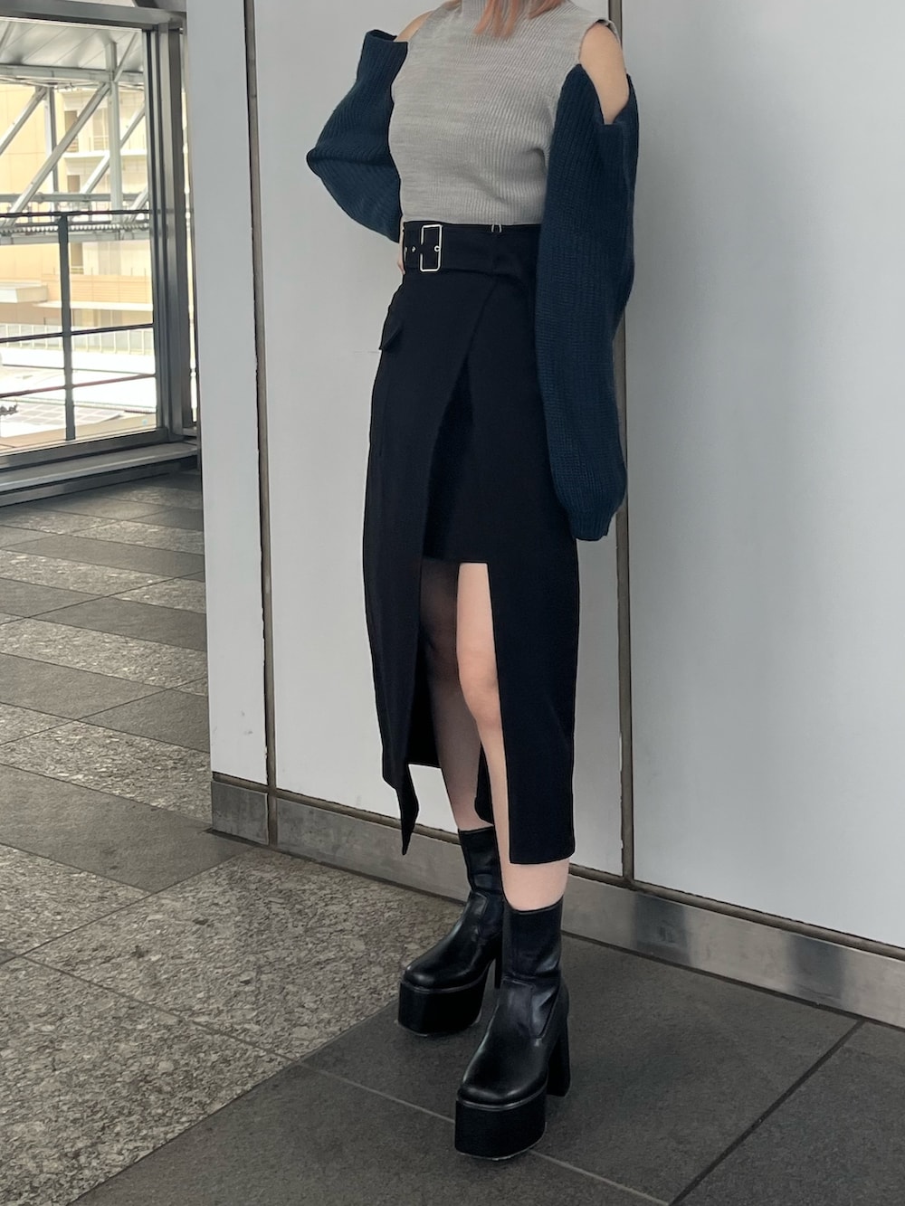 ブラック系のスカート、ブラック系のブーツ、グレー系のニット/セーターを着用したレディースの秋コーディネートの5枚目の写真