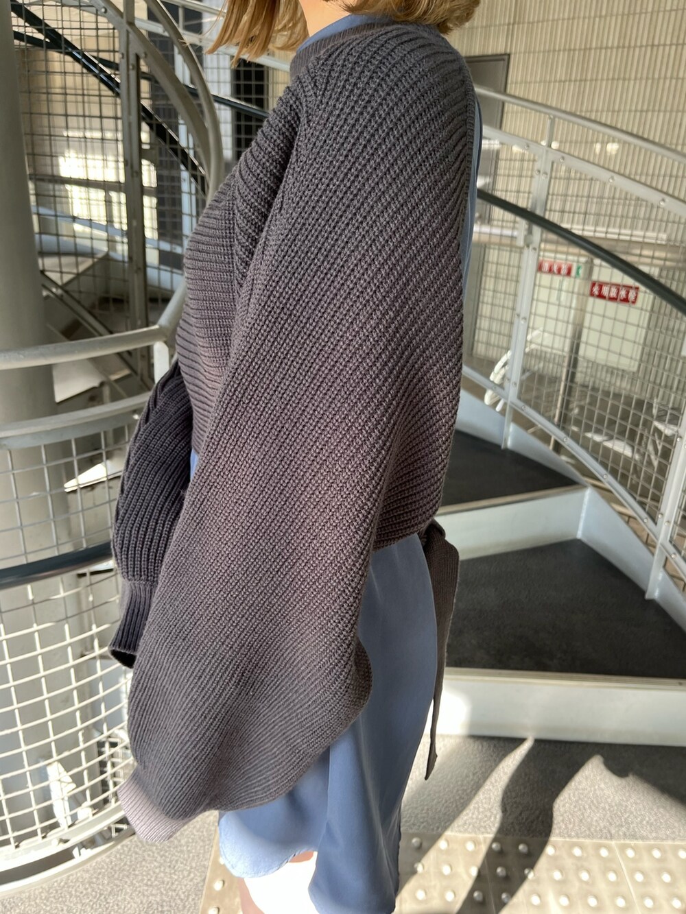 グレー系のワンピース、ブラック系のブーツを着用したレディースの冬コーディネートの6枚目の写真