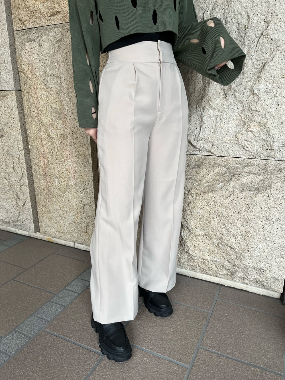 ブラック系のローファー、ベージュ系のスラックス、グリーン系のニット/セーターを着用したレディースの冬コーディネートの3枚目の写真