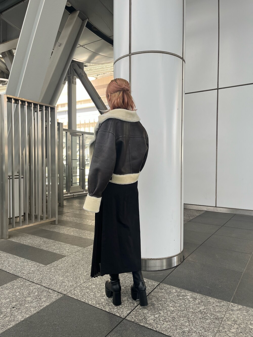 パープル系のニット/セーター、ブラック系のスカート、ブラック系のブーツを着用したレディースの秋コーディネートの4枚目の写真