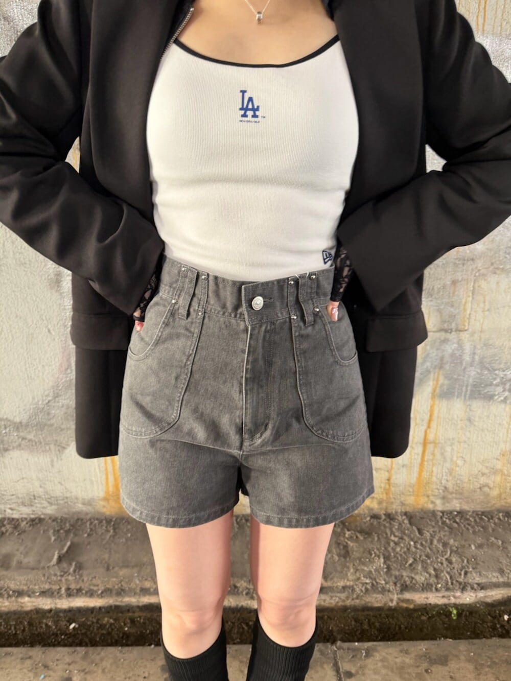 ブラック系のテーラードジャケット、ブラック系のパーカー、ホワイト系のキャミソールを着用したレディースの春コーディネートの7枚目の写真