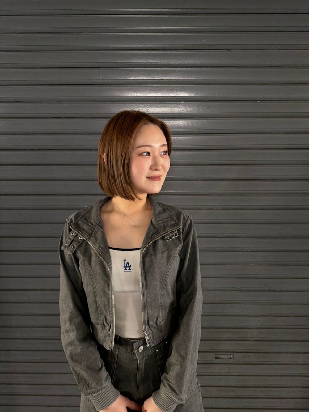 ホワイト系のキャミソール、ブラック系のブーツ、グレー系のその他パンツを着用したレディースの春コーディネートの5枚目の写真