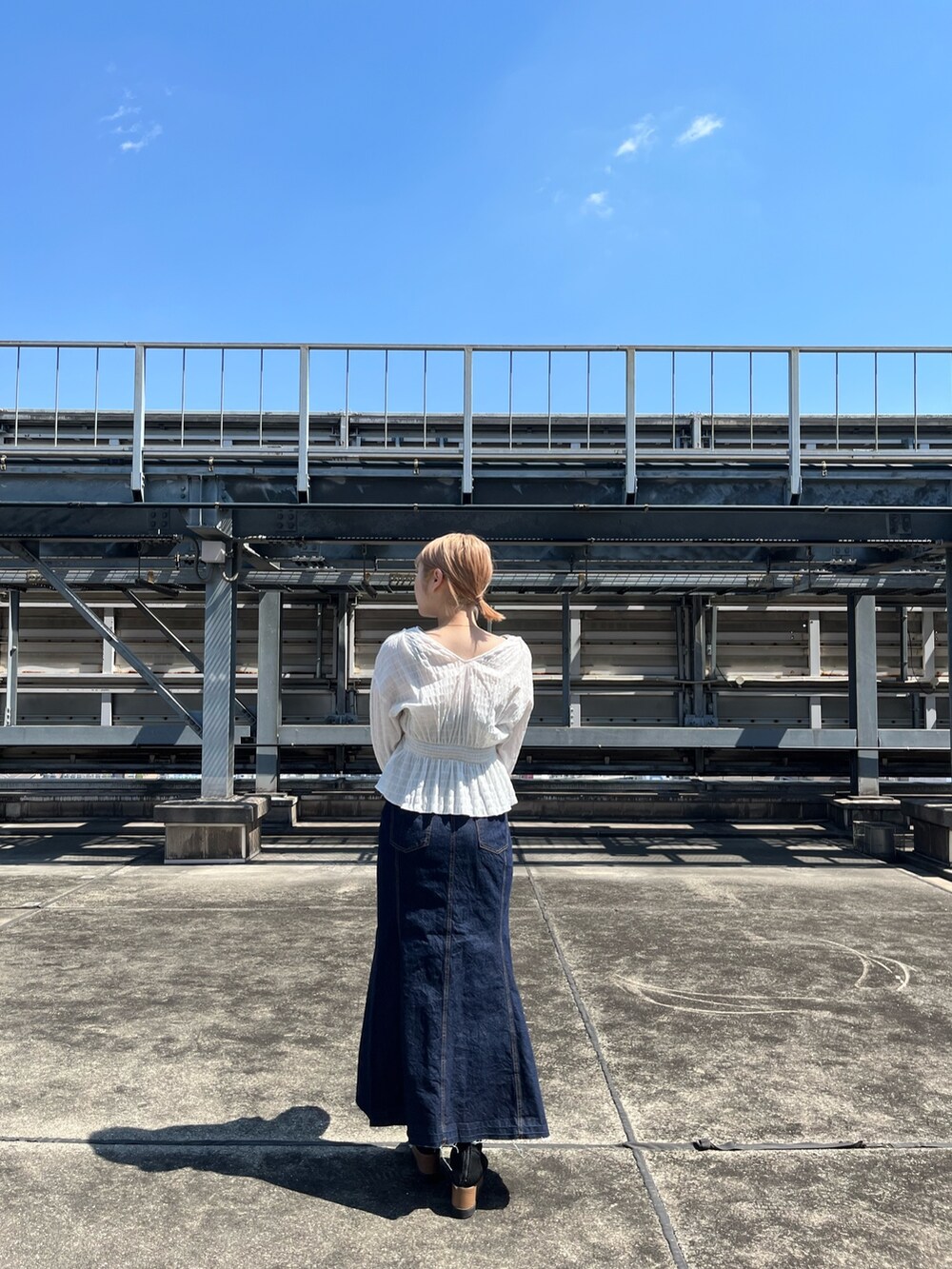 ホワイト系のシャツ/ブラウス、ホワイト系のハンドバッグ、ブラック系のブーツを着用したレディースの春コーディネートの3枚目の写真