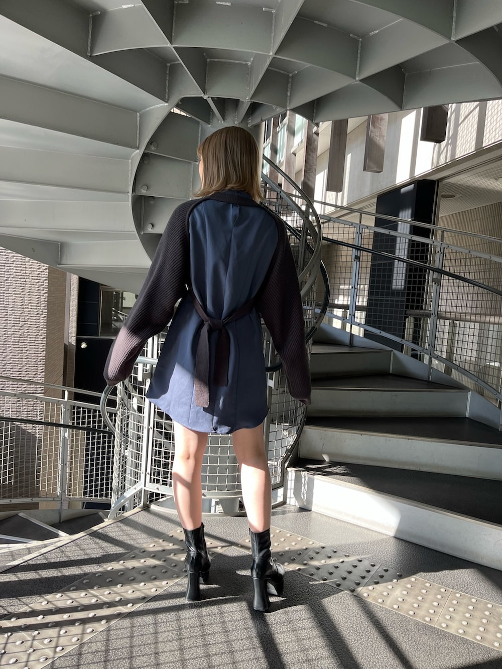 グレー系のワンピース、ブラック系のブーツを着用したレディースの冬コーディネートの3枚目の写真