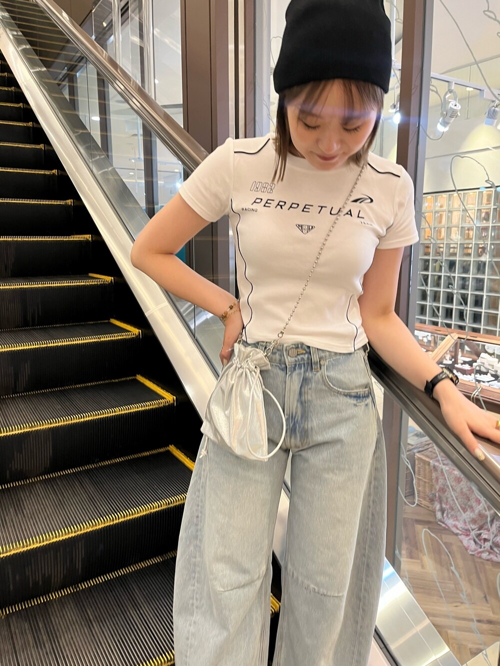 ホワイト系のTシャツ/カットソー、ブルー系のデニムパンツ、ブラック系のパンプスを着用したレディースの夏コーディネートの3枚目の写真