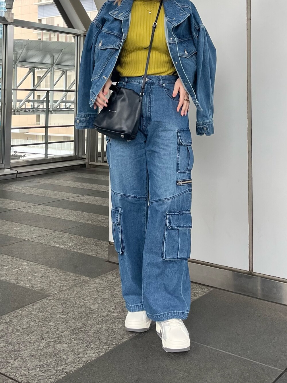 グリーン系のニット/セーター、ブルー系のデニムパンツ、グレー系のスニーカーを着用したレディースの冬コーディネートの4枚目の写真