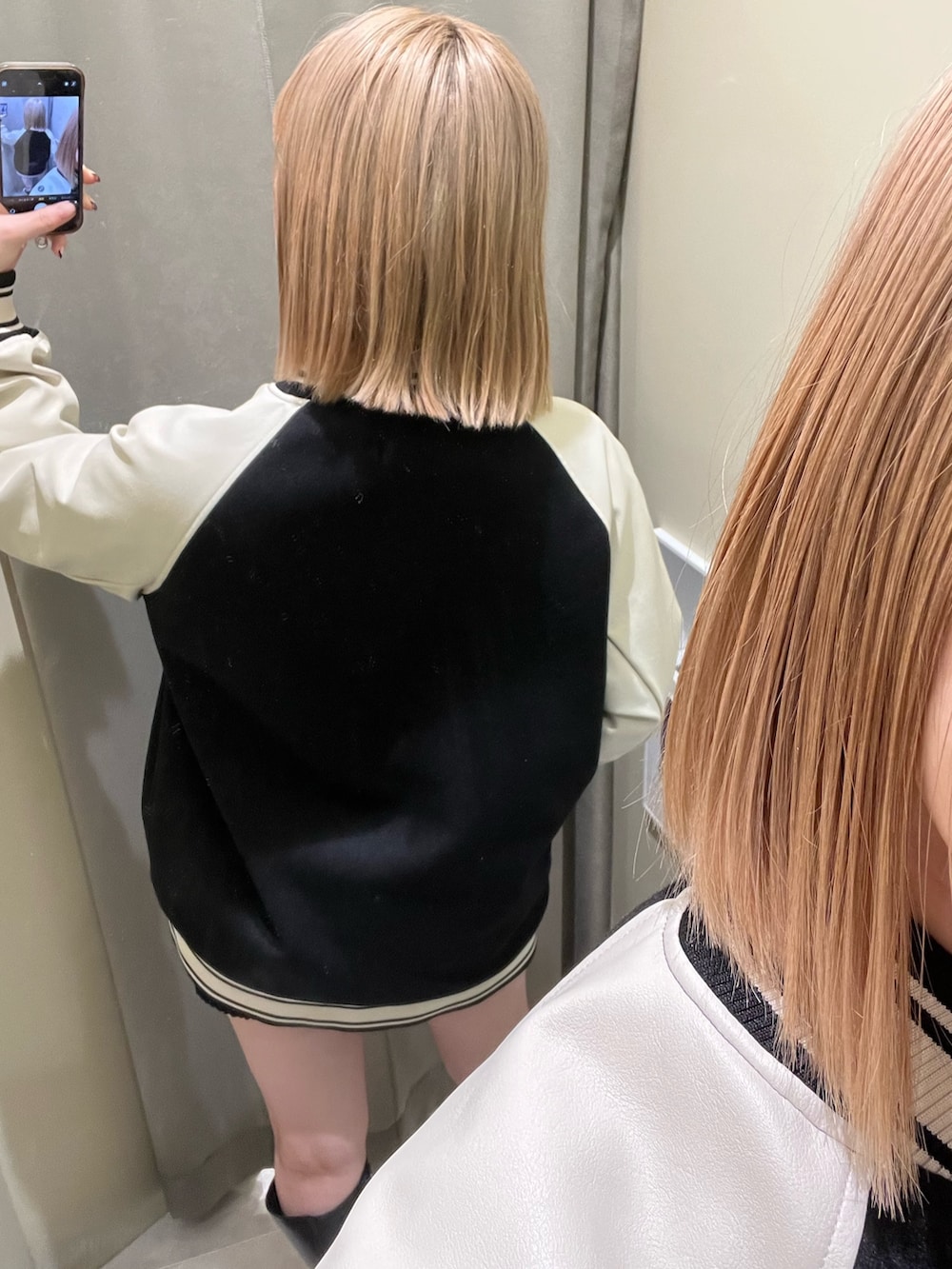 グレー系のスウェット、ブラック系のスウェットパンツ、ブラック系のスタジャンを着用したレディースの秋コーディネートの5枚目の写真