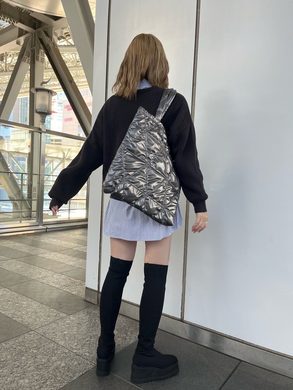 ブラック系のワンピース、グレー系のニット/セーター、グレー系のトートバッグを着用したレディースの冬コーディネートの5枚目の写真