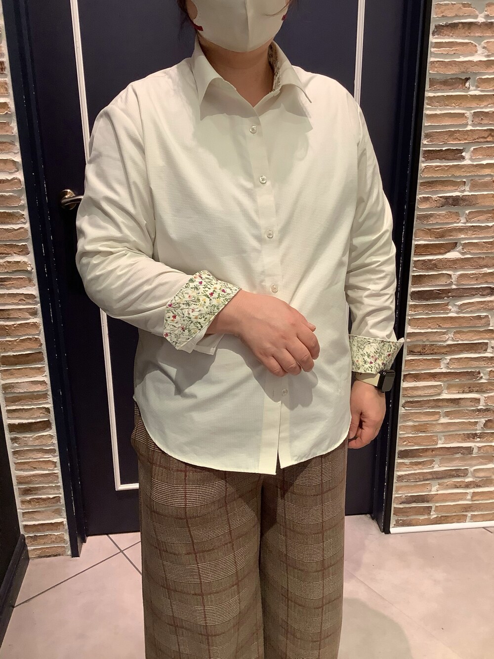 イエロー系のビジネスシャツを着用したレディースの冬コーディネートの2枚目の写真