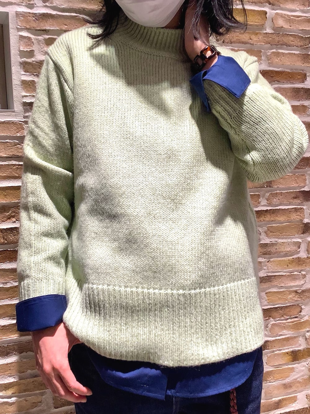 グリーン系のニット/セーター、ブルー系のシャツ/ブラウスを着用したレディースの秋コーディネートの2枚目の写真