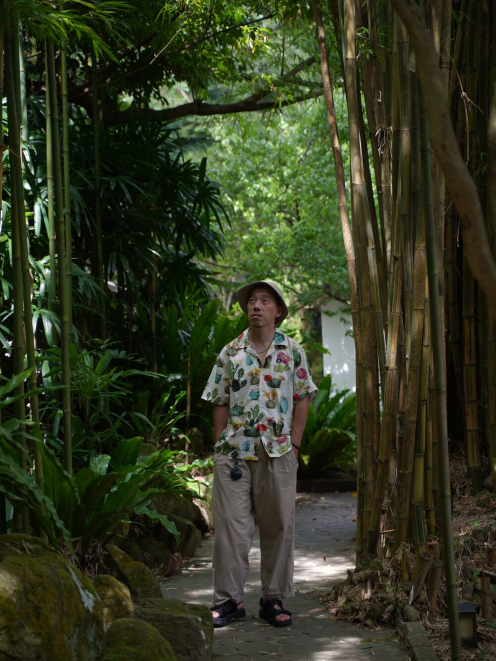 ホワイト系のビジネスシャツ、ブラック系のサンダル、ベージュ系の帽子を着用したメンズの夏コーディネートの2枚目の写真