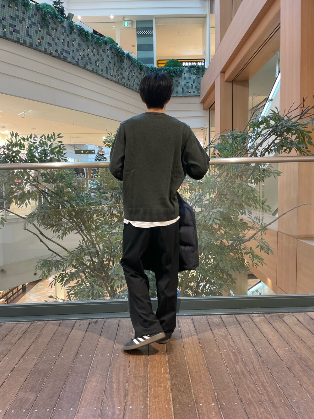 グリーン系のニット/セーター、ブラック系のその他パンツ、ブラック系のダウンジャケット/コートを着用したメンズの秋コーディネートの2枚目の写真