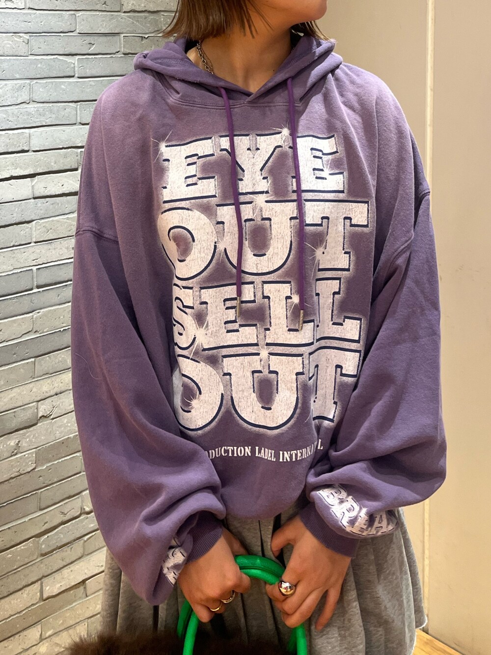 パープル系のTシャツ/カットソー、ブラウン系のトートバッグ、ブラウン系のサンダルを着用したレディースの秋コーディネートの2枚目の写真