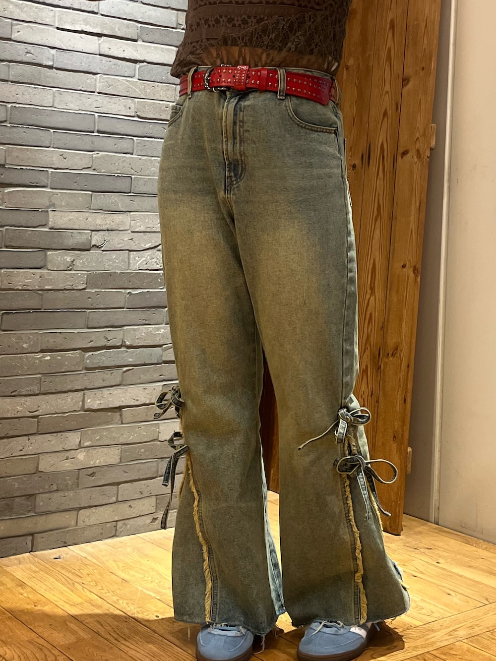 グリーン系のTシャツ/カットソー、ベージュ系のデニムパンツ、レッド系のベルトを着用したレディースの春コーディネートの2枚目の写真