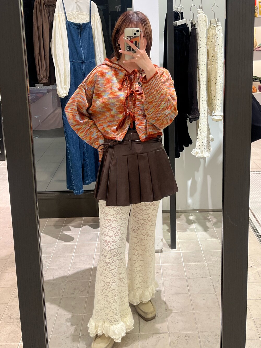 オレンジ系のカーディガン/ボレロ、ブラウン系のスカート、ホワイト系のその他パンツを着用したレディースの秋コーディネートの2枚目の写真