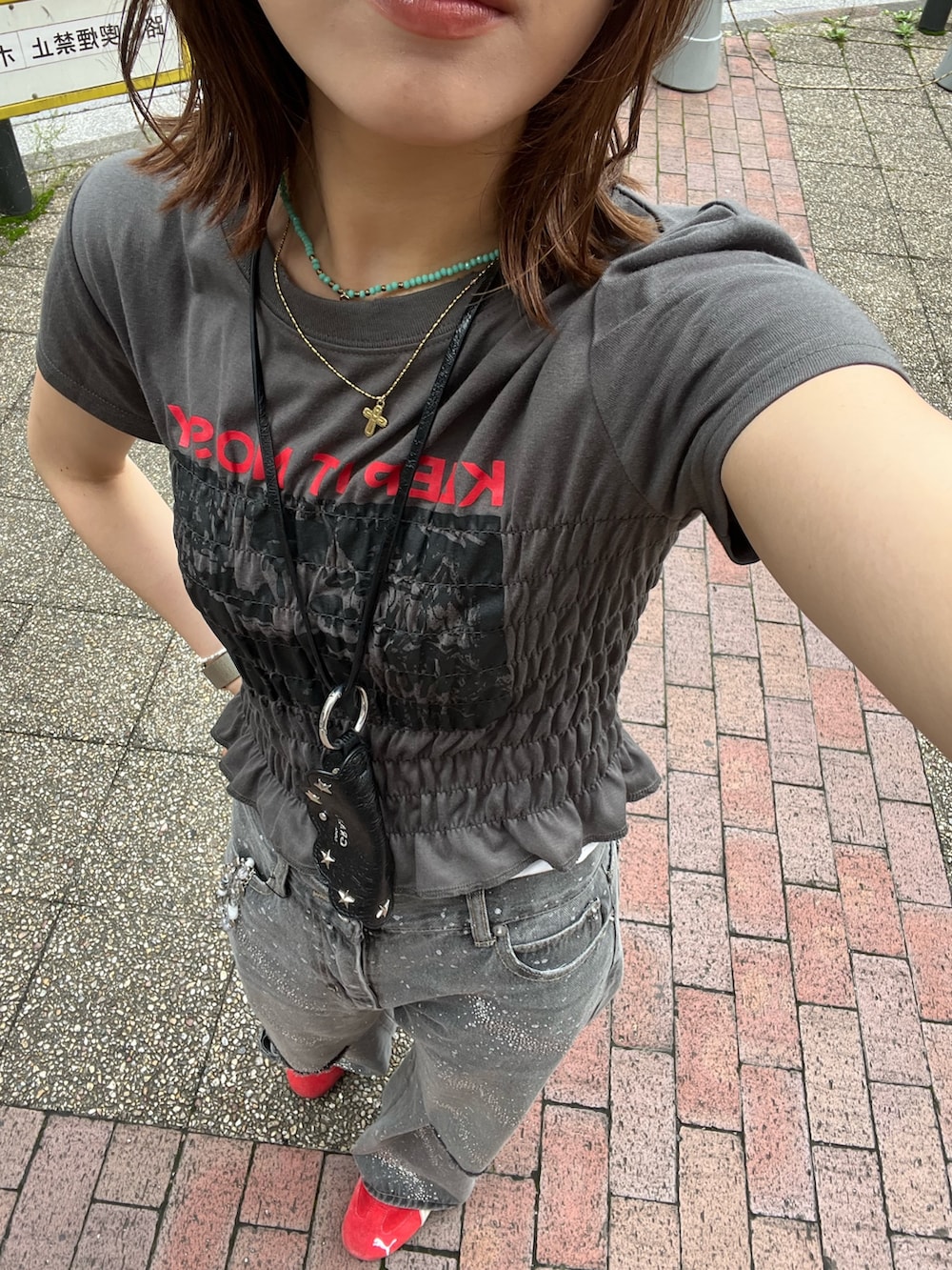 グレー系のTシャツ/カットソー、ブラック系のデニムパンツ、ブラウン系のキャップを着用したレディースの夏コーディネートの2枚目の写真