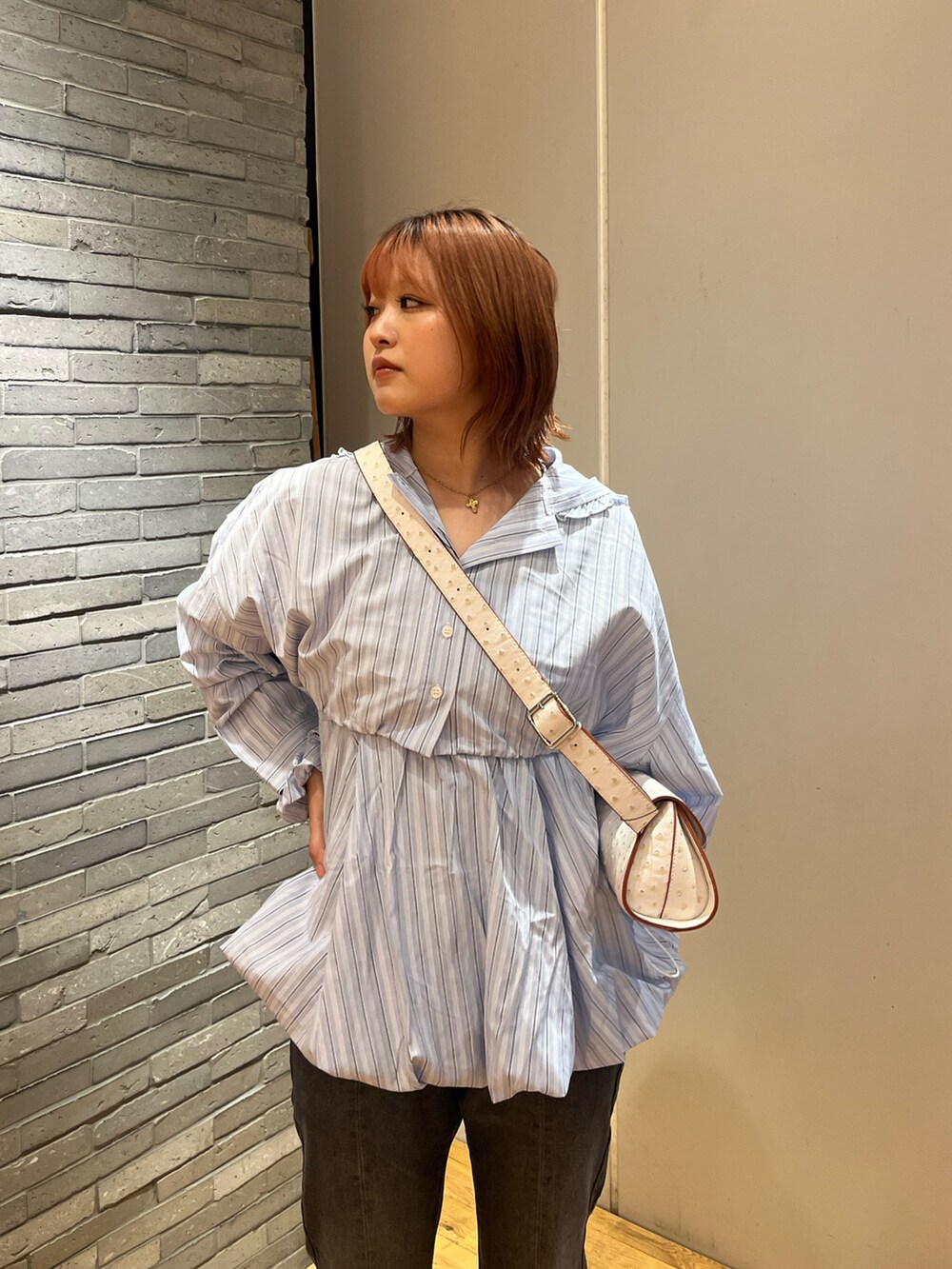 ブルー系のシャツ/ブラウス、ホワイト系のショルダーバッグ、ブラック系のデニムパンツを着用したレディースの夏コーディネートの2枚目の写真