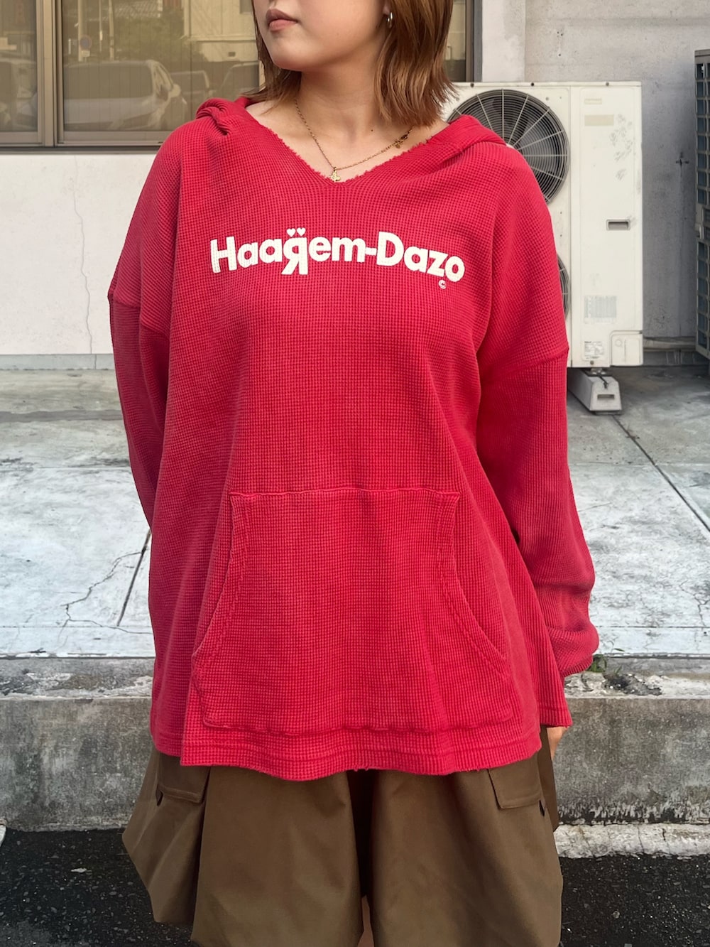レッド系のTシャツ/カットソー、ブラウン系のスカート、ブラウン系のサンダルを着用したレディースの秋コーディネートの2枚目の写真