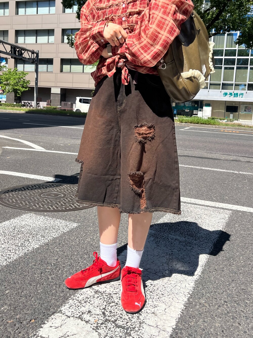 ブラウン系のその他パンツ、ブラウン系のショルダーバッグ、レッド系のシャツ/ブラウスを着用したレディースの夏コーディネートの3枚目の写真