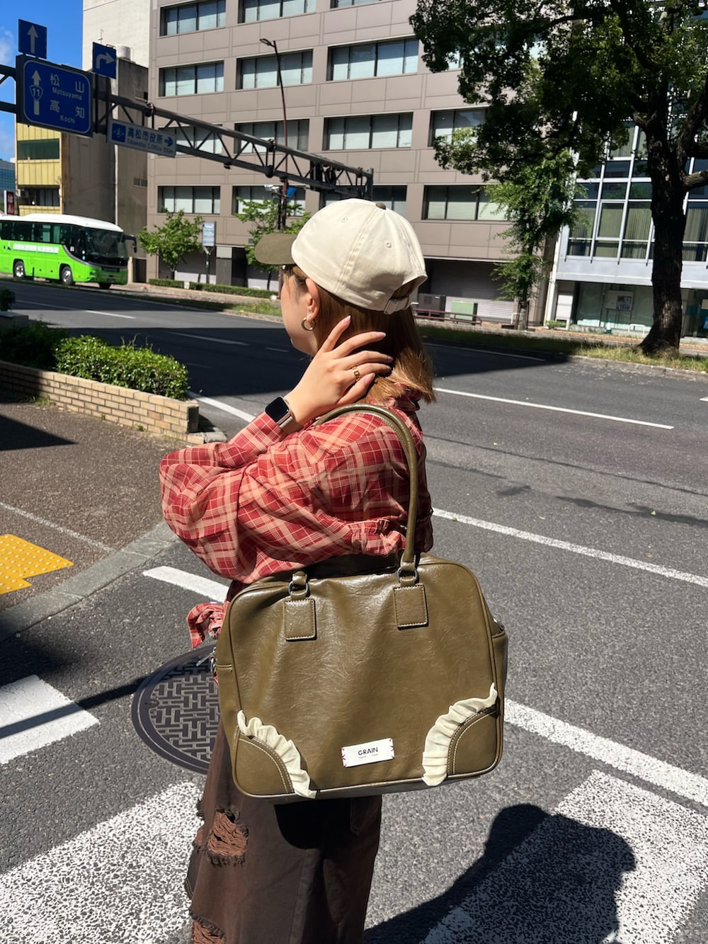 ブラウン系のその他パンツ、ブラウン系のショルダーバッグ、レッド系のシャツ/ブラウスを着用したレディースの夏コーディネートの2枚目の写真