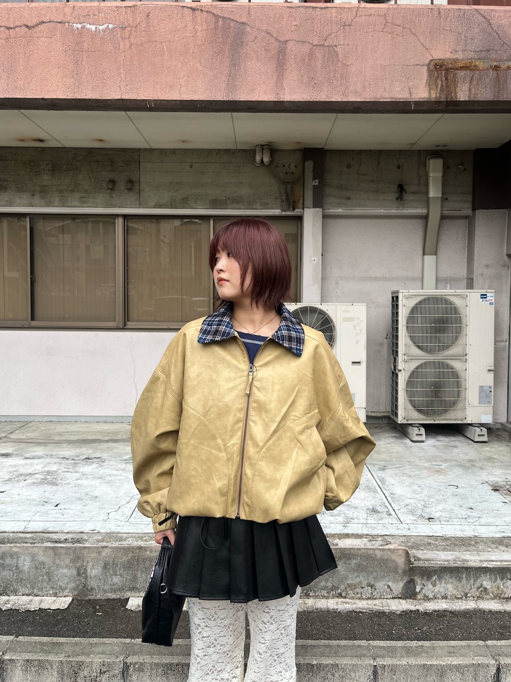 ベージュ系のブルゾン、ブラック系のスカート、ホワイト系のその他パンツを着用したレディースの秋コーディネートの2枚目の写真