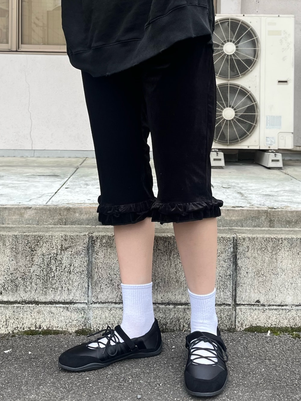 ブラック系のTシャツ/カットソー、ブラック系のその他パンツ、レッド系のトートバッグを着用したレディースの秋コーディネートの3枚目の写真