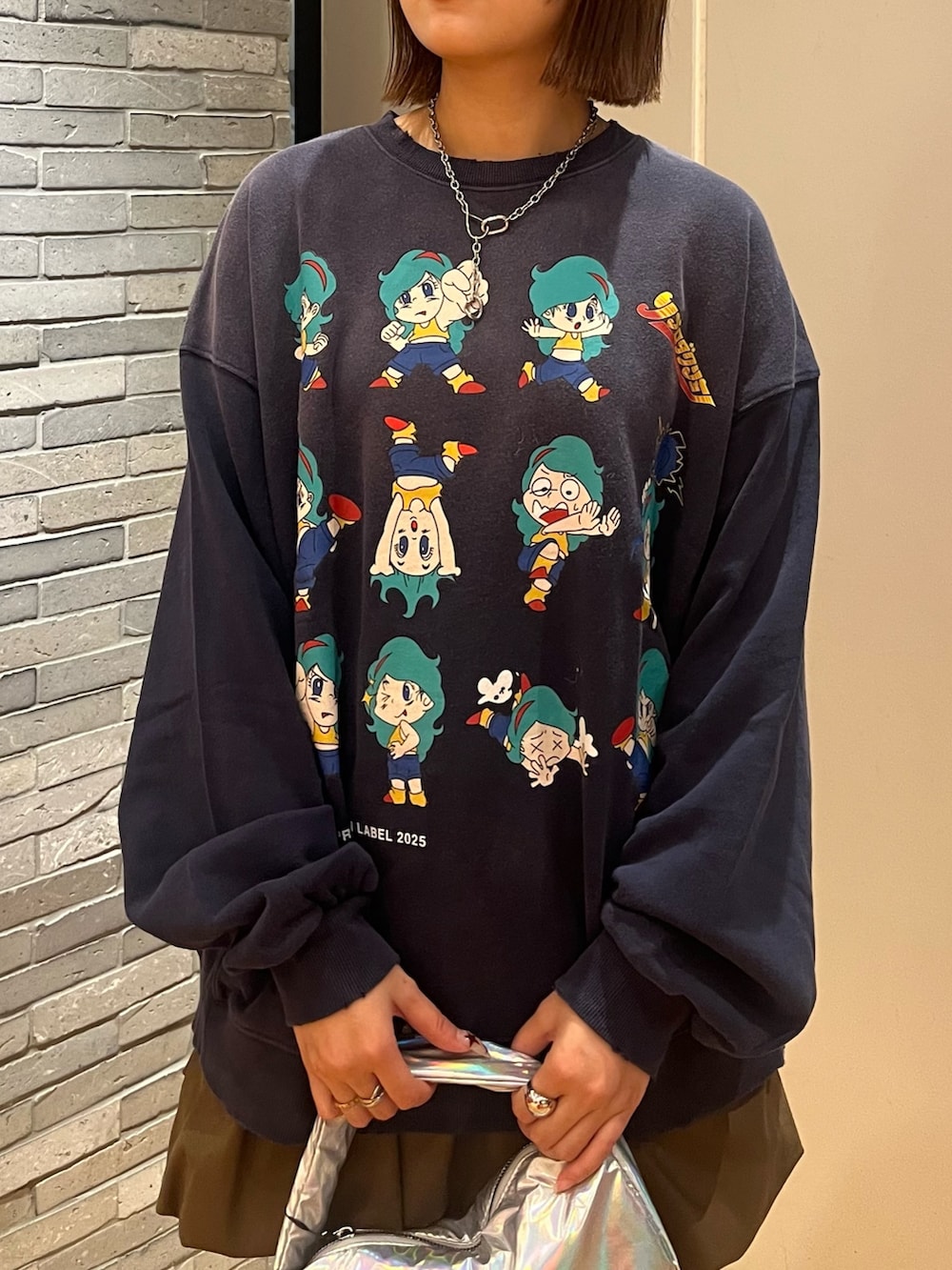 ブルー系のTシャツ/カットソー、ブラウン系のスカート、ブラウン系のサンダルを着用したレディースの秋コーディネートの2枚目の写真