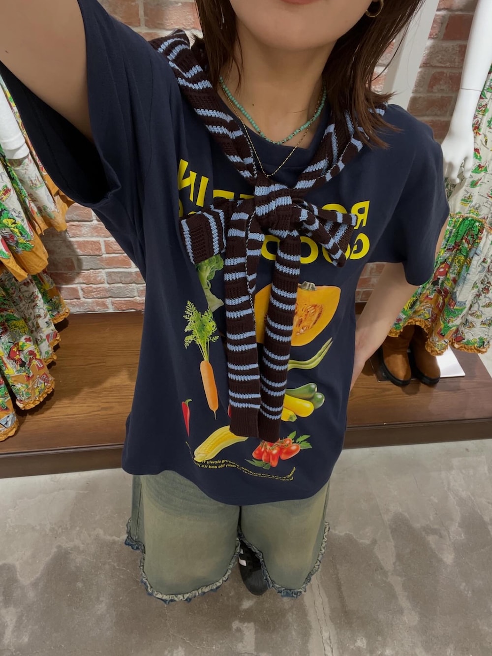 ブルー系のTシャツ/カットソー、ブルー系のデニムパンツ、ブラウン系のストール/ショールを着用したレディースの夏コーディネートの2枚目の写真