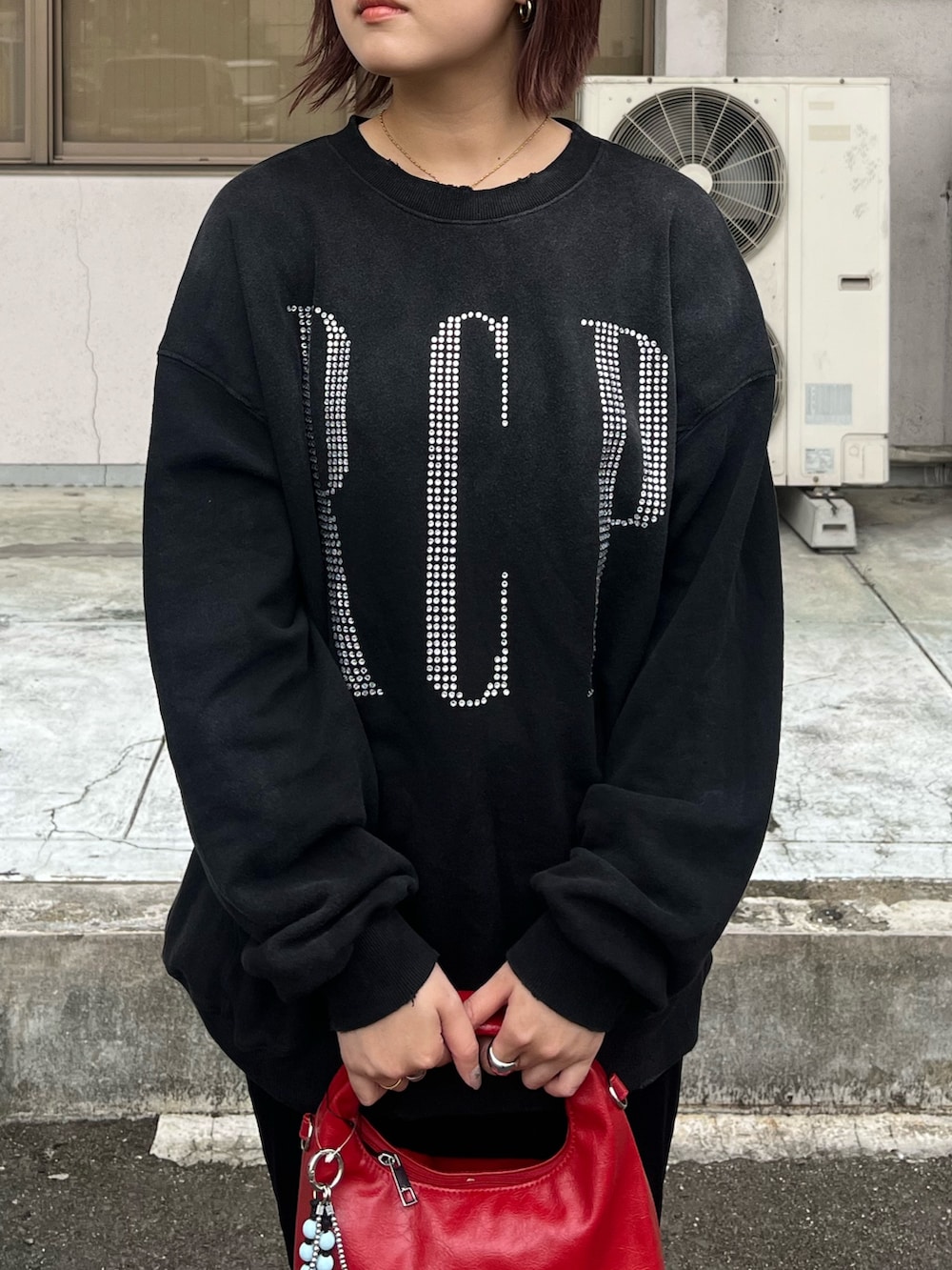 ブラック系のTシャツ/カットソー、ブラック系のその他パンツ、レッド系のトートバッグを着用したレディースの秋コーディネートの2枚目の写真