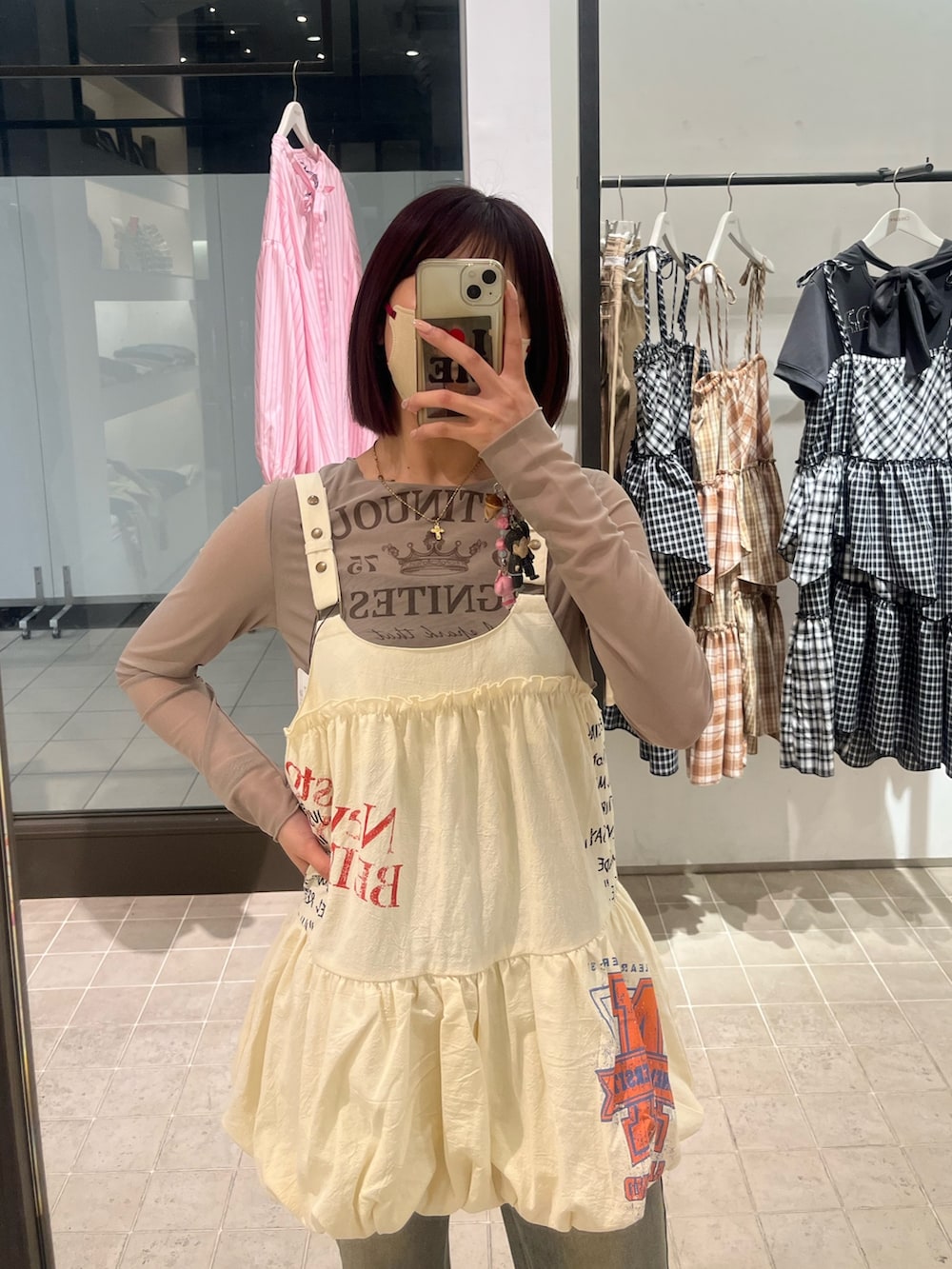 ブラウン系のTシャツ/カットソー、ホワイト系のチュニック、ブルー系のデニムパンツを着用したレディースの春コーディネートの2枚目の写真