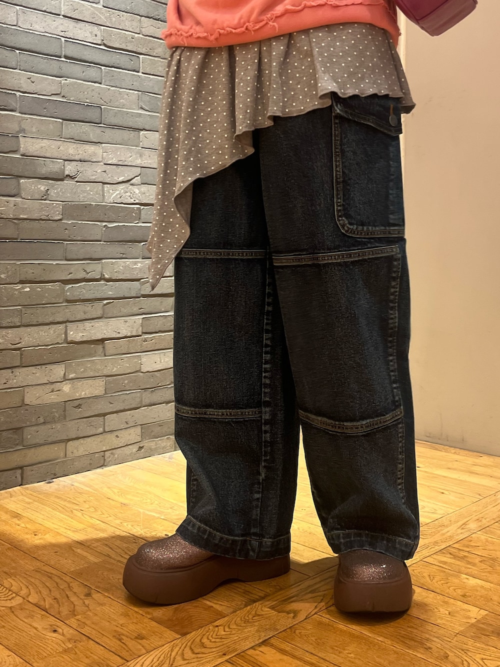 ピンク系のTシャツ/カットソー、グレー系のワンピース、ブルー系のデニムパンツを着用したレディースの秋コーディネートの3枚目の写真