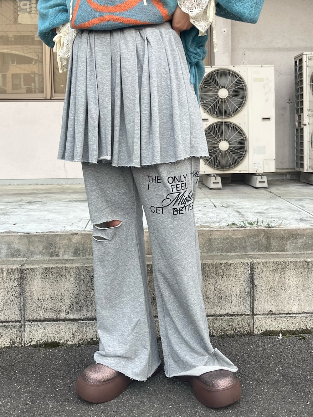 ブルー系のニット/セーター、ホワイト系のTシャツ/カットソー、グレー系のその他パンツを着用したレディースの秋コーディネートの3枚目の写真