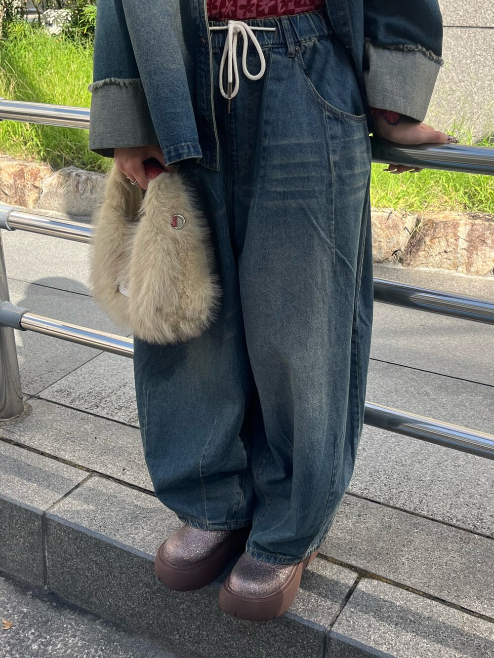 レッド系のTシャツ/カットソー、ブルー系のシャツ/ブラウス、ブルー系のデニムパンツを着用したレディースの秋コーディネートの2枚目の写真