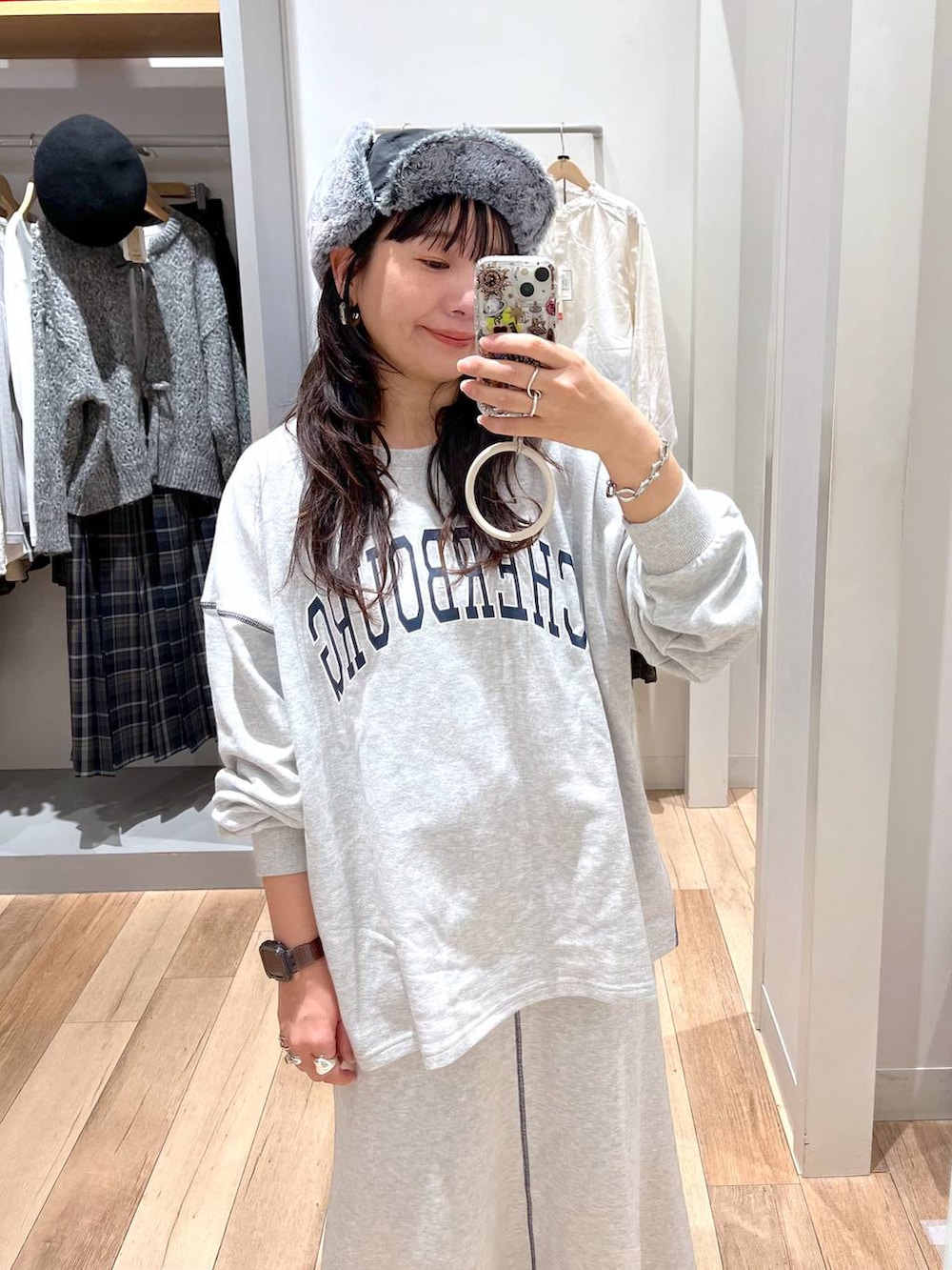 グレー系のスウェット、グレー系のスカート、ブラック系のキャップを着用したレディースの秋コーディネートの3枚目の写真