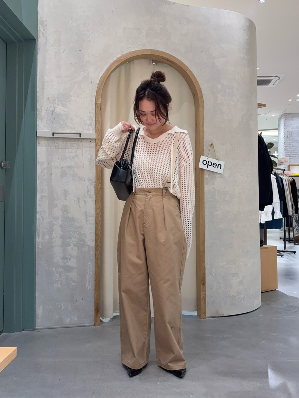 ホワイト系のニット/セーター、ベージュ系のサロペット/オーバーオール、ブラック系のバッグを着用したレディースの春コーディネートの2枚目の写真