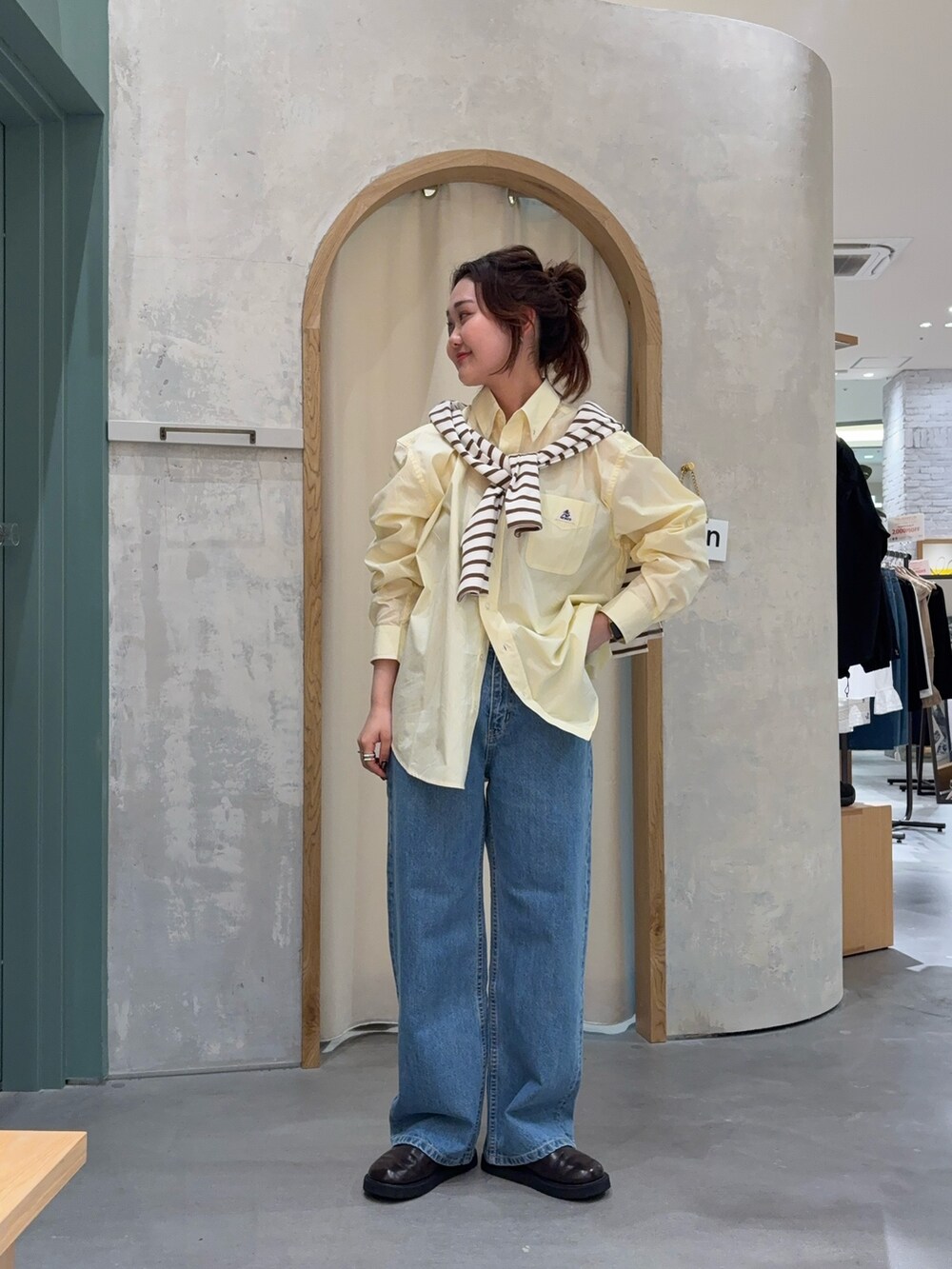 イエロー系のシャツ/ブラウス、ブラウン系のTシャツ/カットソー、ブルー系のデニムパンツを着用したレディースの春コーディネートの2枚目の写真