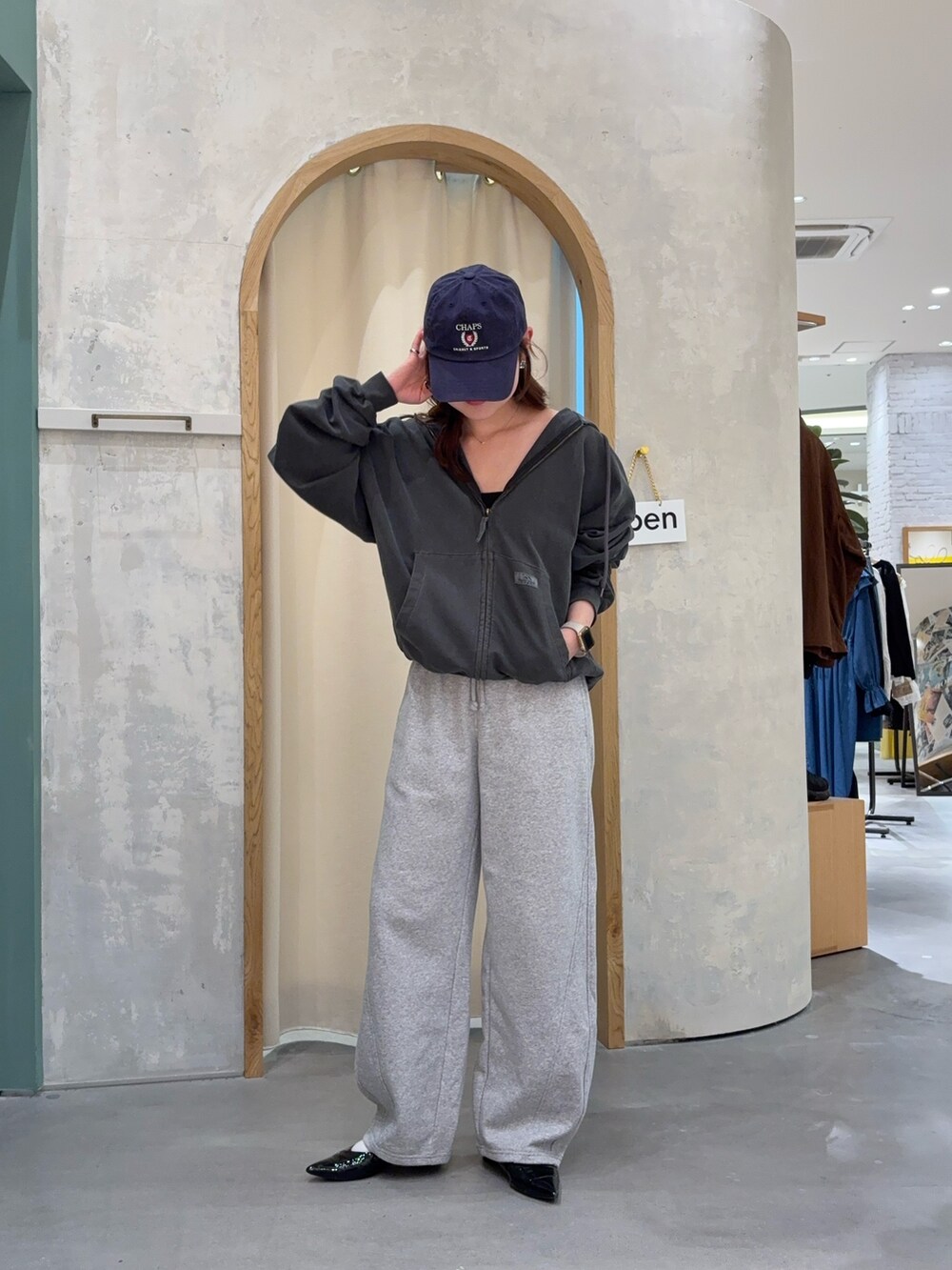 ブラック系のパーカーを着用したレディースの春コーディネートの2枚目の写真