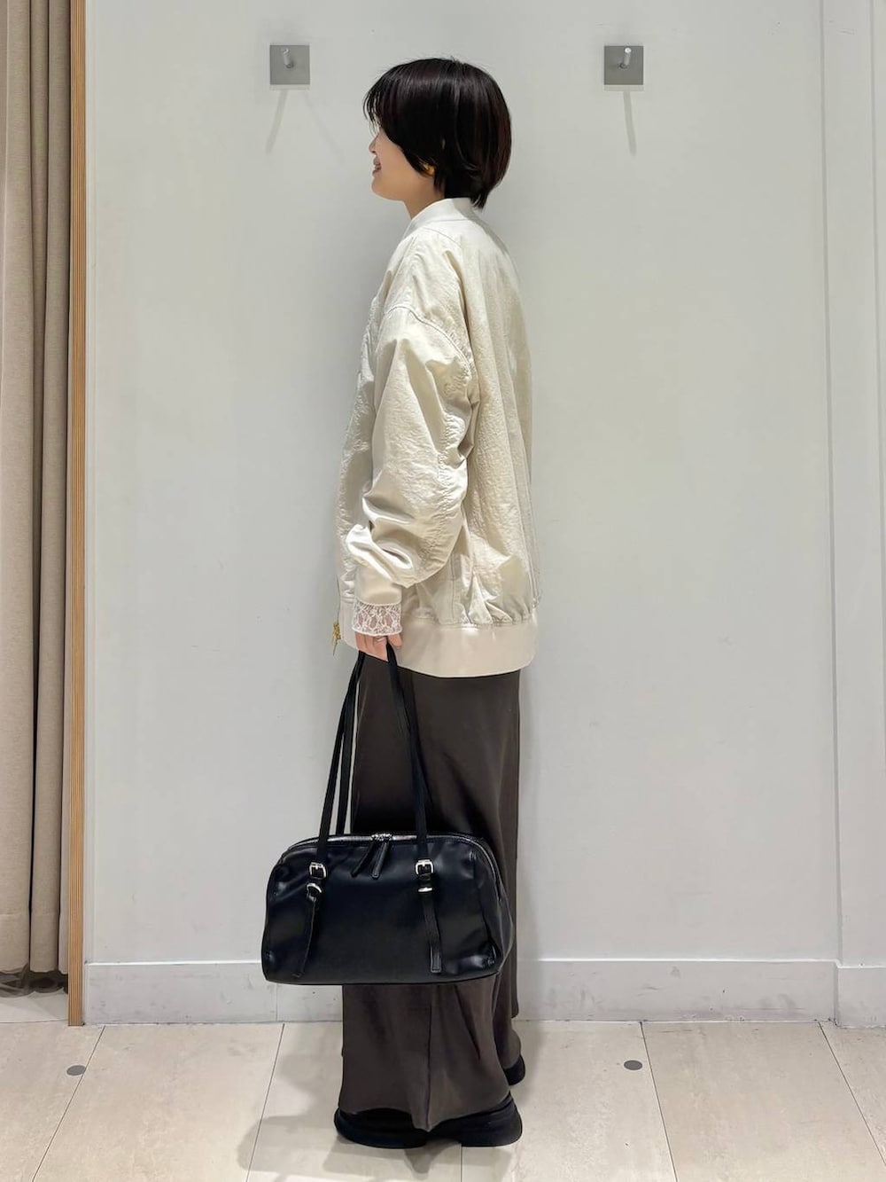 ホワイト系のTシャツ/カットソー、ベージュ系のブルゾン、ブラウン系のスカートを着用したレディースの春コーディネートの3枚目の写真