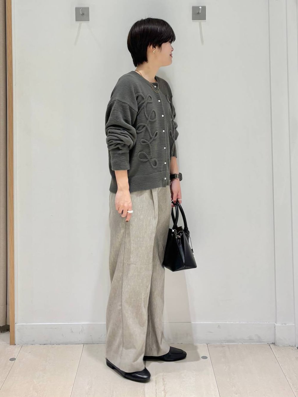 ブラック系のローファー、ブラック系のショルダーバッグ、ベージュ系のその他パンツを着用したレディースの秋コーディネートの4枚目の写真